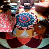 A colorful circular rug with floral patterns in a cozy living room setting.