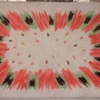 Handmade rug with a radial pattern resembling a watermelon slice.
