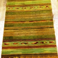 A colorful striped rug with earthy tones and patterned details displayed on a floor.