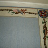 Decorative carpet with nautical-themed border featuring a compass, rope, and floral design.