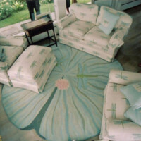 A living room with floral-patterned sofas and a matching round carpet, featuring a soft color palette.