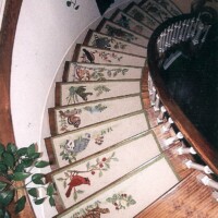 A spiral staircase with ornate, floral-patterned tiles, accompanied by plants and decorative elements.