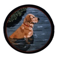 A circular rug featuring an embroidered design of a golden retriever sitting by a body of water with trees in the background.
