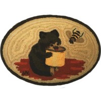 An oval rug featuring an illustration of a bear eating honey from a pot with a bee flying nearby.