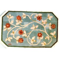A floral patterned area rug with an octagonal shape on a plain background.