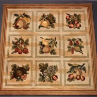 A decorative rug featuring a patchwork of various fruit and foliage designs.
