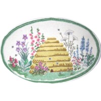 An embroidered patch depicting a bee skep with surrounding flowers on an oval background.