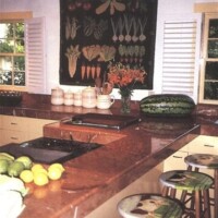 A kitchen interior with a food-themed painting, marble countertops, and fresh produce on display.