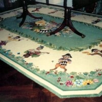 An intricately designed area rug featuring cartoonish animals and floral motifs, with furniture legs resting on it.