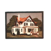 Embroidered depiction of a two-story house with a red roof and surrounding greenery.
