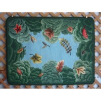 A decorative doormat featuring an autumnal theme with colorful fallen leaves and a blue sky.