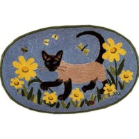 Embroidered patch featuring a siamese cat walking among yellow flowers against a blue background.
