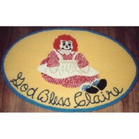 An oval-shaped rug with an image of a clown and the text "god bless claire" embroidered on it.