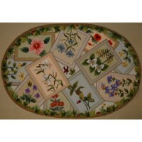 Oval-shaped floral needlework with various plant and insect designs on a beige background.