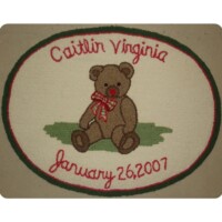 Embroidered keepsake with a teddy bear, a personalized name 'caitlin virginia', and the date 'january 26, 2007'.