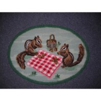 Embroidery of two squirrels at a picnic with a checkered cloth and a basket on a circular background.