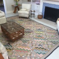 A cozy living room with patterned carpet, a fireplace, and comfortable seating arrangements.