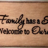 Welcome mat with the inscription "every family has a story... welcome to ours" on it.