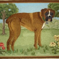 Handcrafted textile depicting a brown dog with a black face in a garden scene.