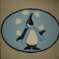 Cartoon-style penguin with a scarf on a blue oval background rug.