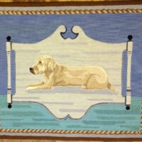 Illustration of a golden retriever lying on a dock by the water, framed with a rope border.