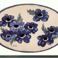 Embroidered blue flowers on an oval beige background.