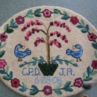 Handcrafted oval rug with floral and bird design, personalized with initials "c.p.d. jr." and the date "6/23/09".