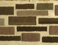 A long, rectangular rug with a geometric pattern of colored blocks.