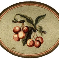 Embroidered fruit motif on a circular fabric background.