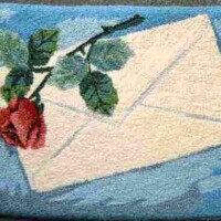 An embroidered depiction of an envelope with a red flower resting on top.