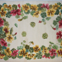 Floral embroidery with yellow and pink flowers on a fabric canvas.