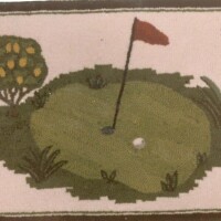Embroidered depiction of a golf course green with a flagstick, hole, and surrounding foliage.
