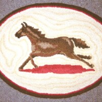 Oval-shaped rug featuring a horse design with concentric decorative borders.
