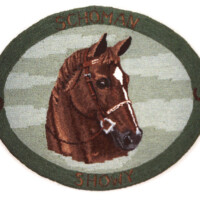 Embroidered patch featuring a horse's head with text "schoman showy" within a green border.