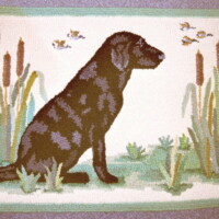 A tapestry depicting a seated dog in profile, surrounded by reeds and butterflies.