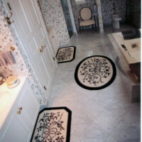 A floral-patterned bathroom with coordinating mats and wallpaper.