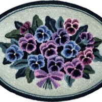 Oval-shaped floral rug with a bouquet of purple and blue flowers tied with a ribbon.