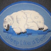 Round rug with a polar bear design and the text "sleep like a bear".