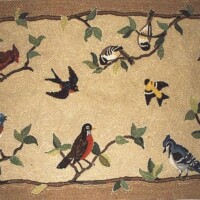 Handcrafted rug featuring a variety of colorful birds perched on and flying between branches.