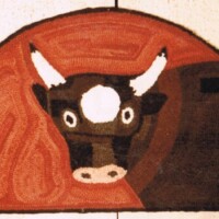 Semi-circular doormat with a cartoon bull's head design against a red background.