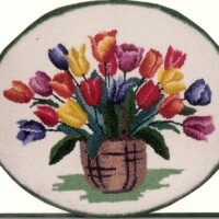 Embroidered bouquet of colorful tulips displayed in a basket on a round canvas.