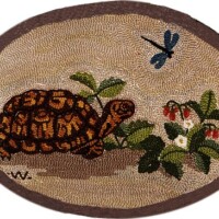Embroidered turtle and flowers on an oval fabric patch.