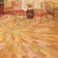 A vintage room with a sunburst-patterned carpet, two wooden chairs, and a small table with flowers.