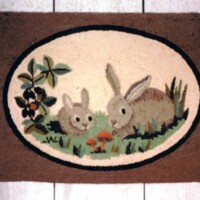 Oval rug with a bunny-themed design, featuring two rabbits, greenery, and a mushroom.